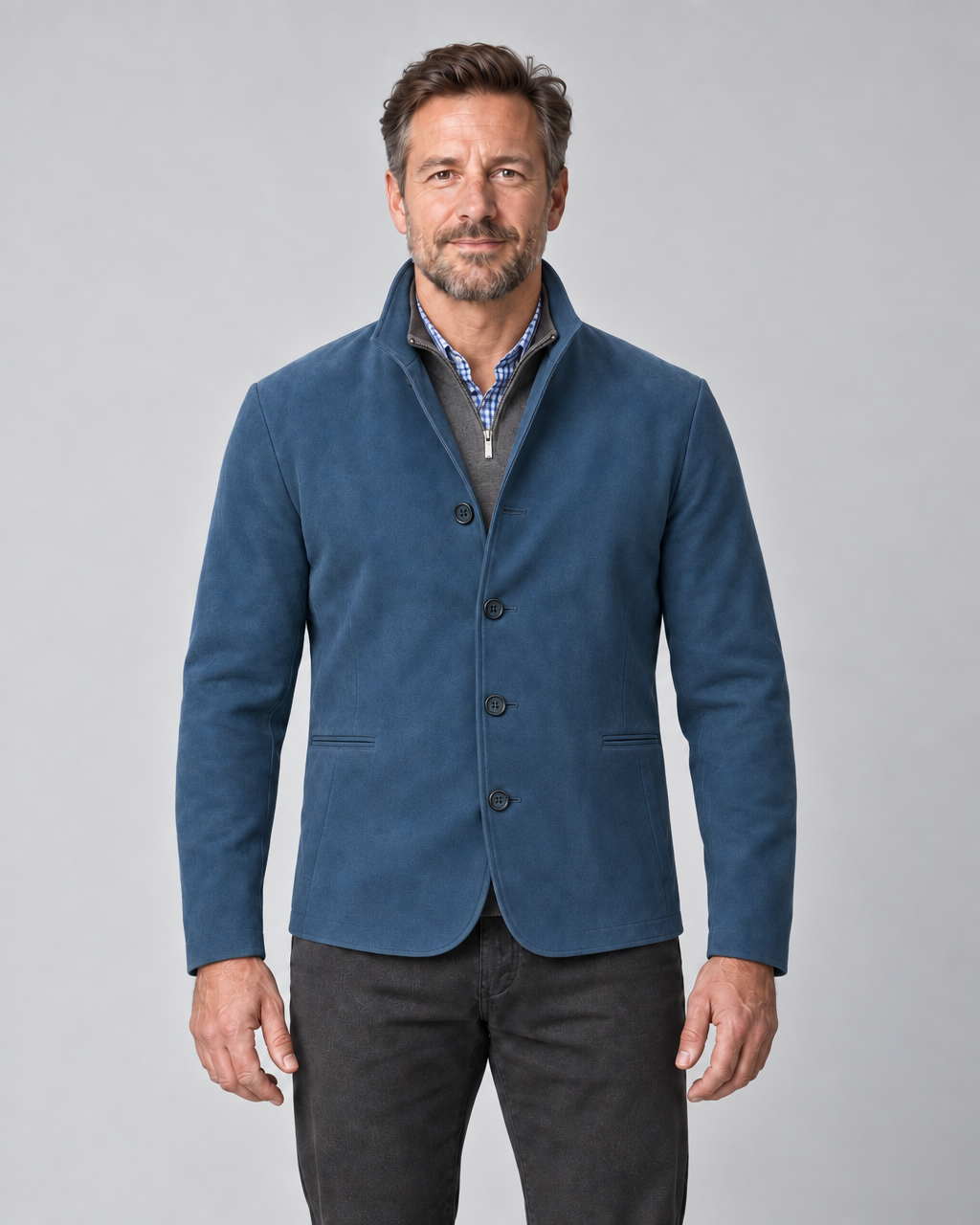 Front cropped view of a man wearing a blue four-button blazer with a stand collar and two welt pockets