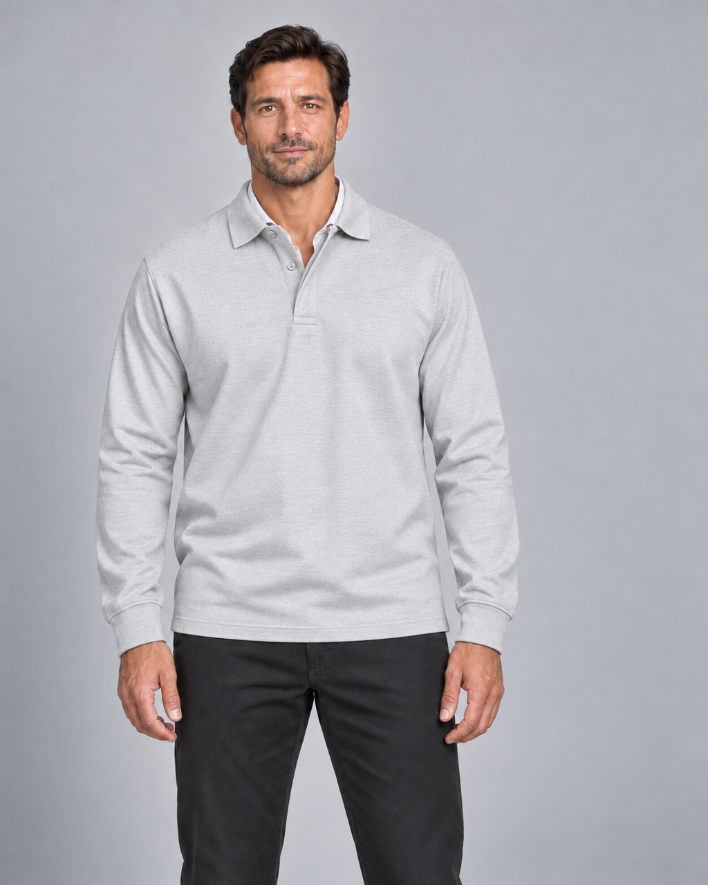 Front cropped view of a man wearing a white long-sleeve polo shirt with a subtle textured pattern