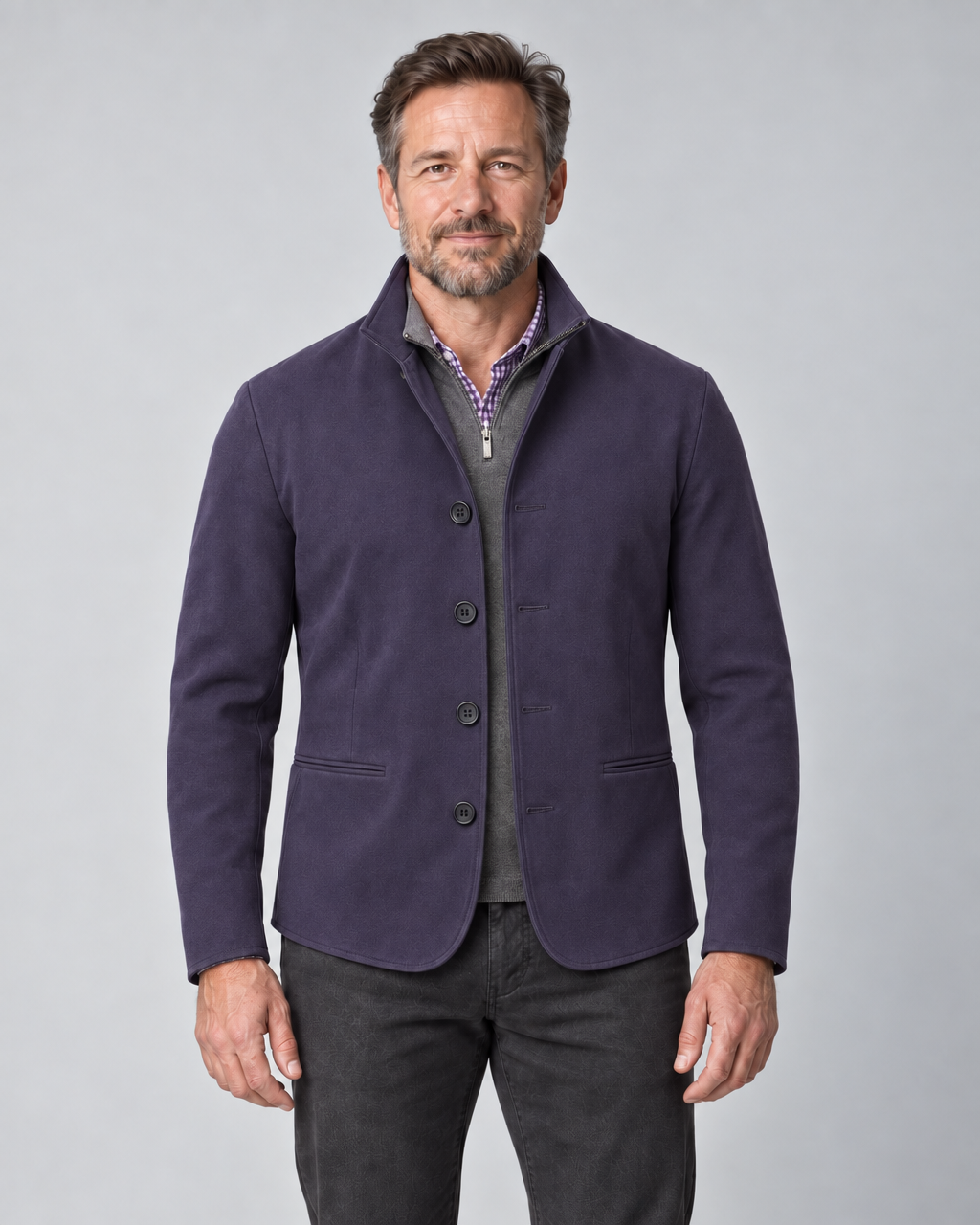 Front cropped view of a man wearing a violet four-button blazer with a stand collar and two welt pockets.