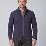 Front cropped view of a man wearing a violet four-button blazer with a stand collar and two welt pockets.