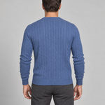 Back view of a man wearing a blue cable-knit crew-neck jumper with ribbed cuffs and hem