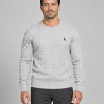 Front cropped view of a light grey cable-knit crew-neck jumper with a small dark chest motif