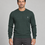 Front cropped view of a model wearing a dark green cable-knit crew-neck jumper with a small white chest motif