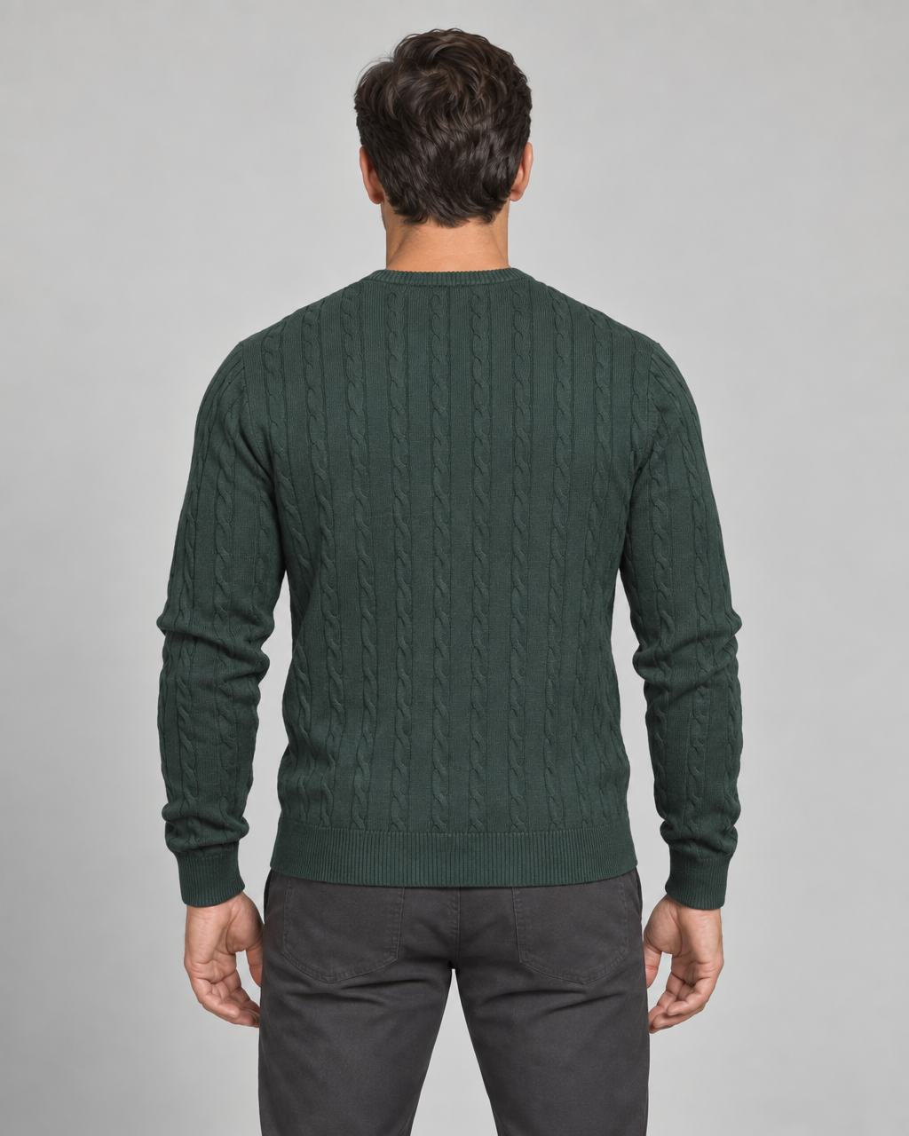 Back view of a man wearing a dark green cable-knit crew-neck jumper with long sleeves and ribbed trims.