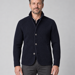 Front cropped view of a man wearing a marine blue textured jacket with a raised collar and three-button fastening
