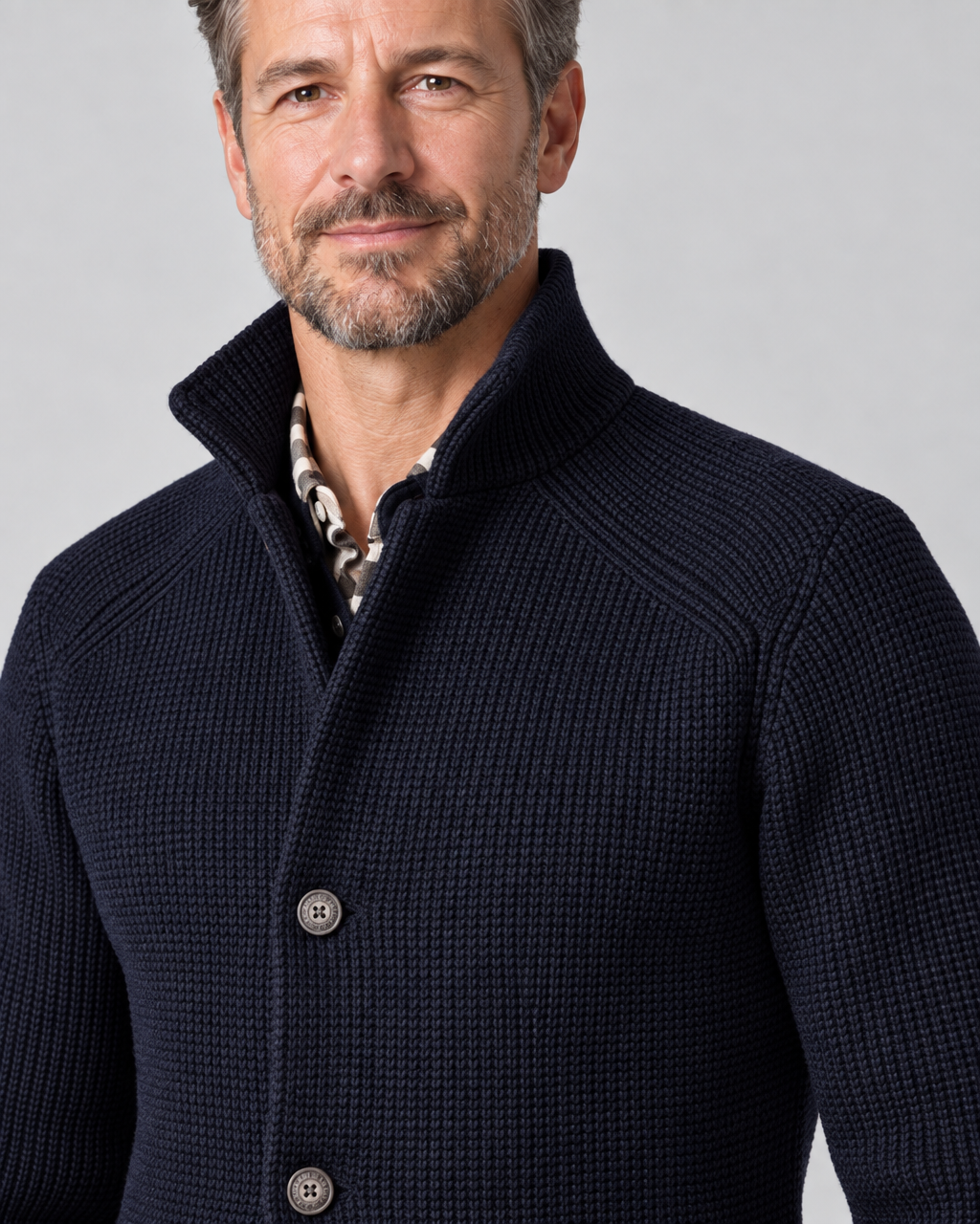 Close-up of a man wearing a navy textured jacket with a raised collar and button front.
