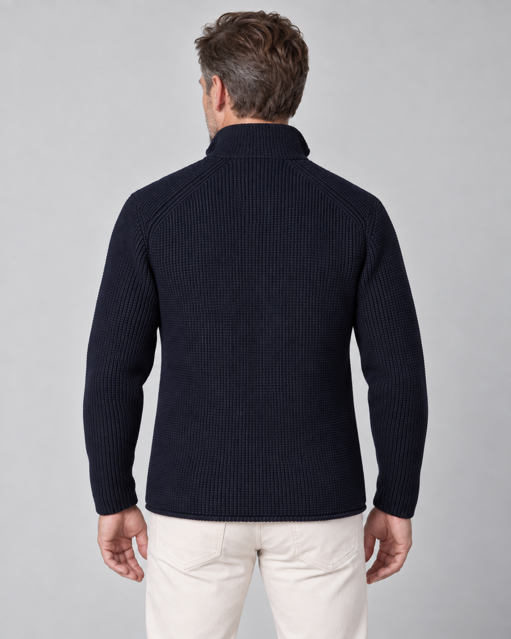 Back view of a man wearing a dark navy rib-knit jacket with a high collar and long sleeves.