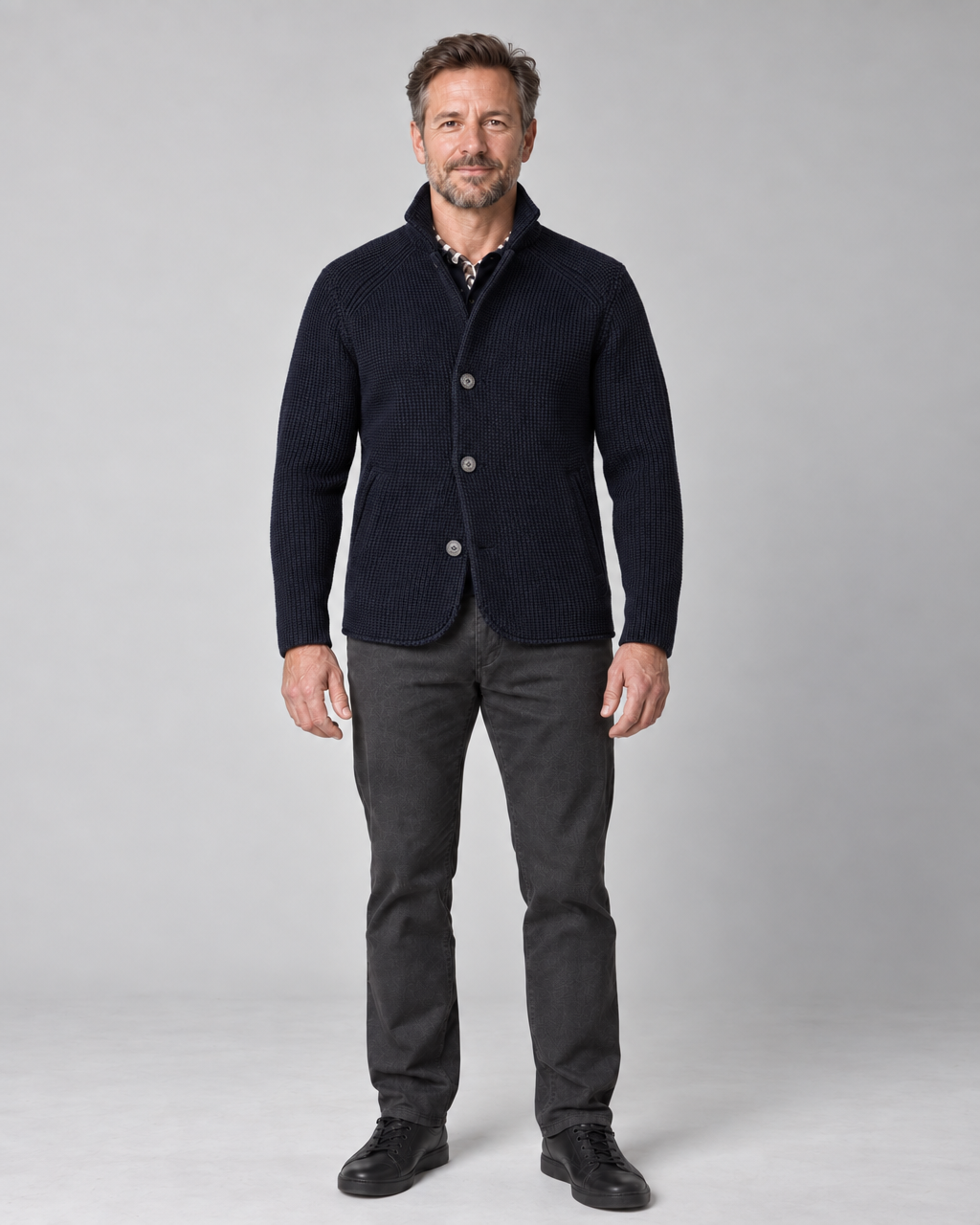 Full-length front view of a man wearing a marine blue textured button-up jacket with a raised collar