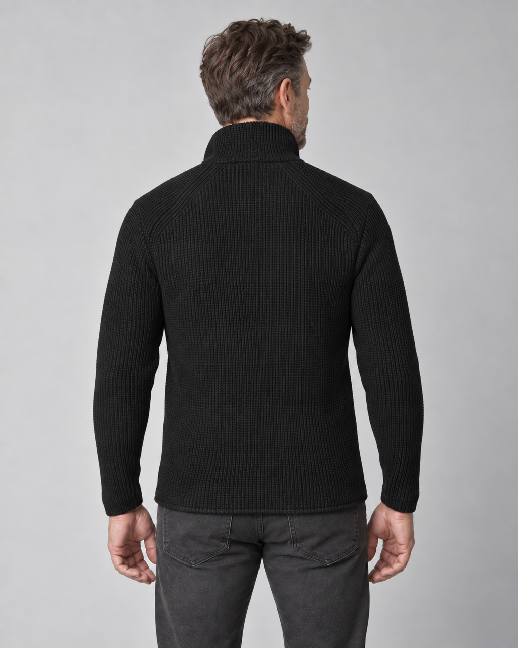 Back view of a man wearing a black ribbed knit jacket with a high collar and long sleeves