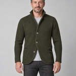 Front cropped view of a man wearing a dark green textured button-up jacket with a stand collar and patch pockets
