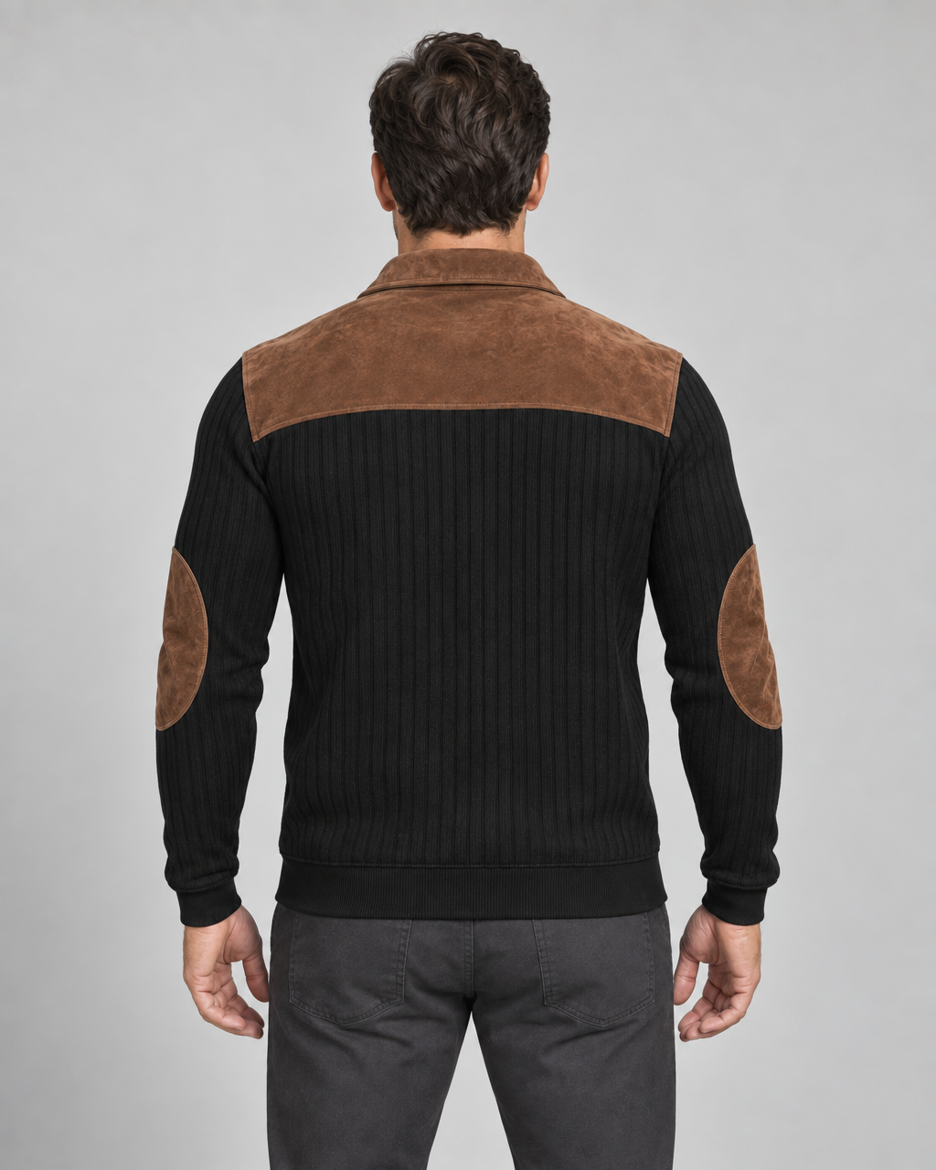 Back crop of a black ribbed men's sweater with a brown shoulder yoke, collar and elbow patches