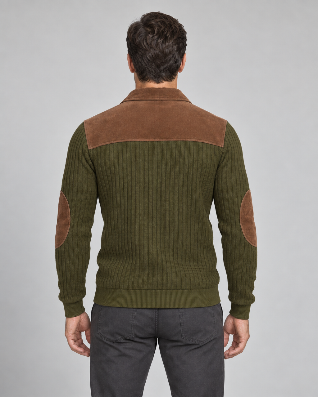 Back view of a man in an olive-green ribbed jumper with a brown shoulder panel and elbow patches.