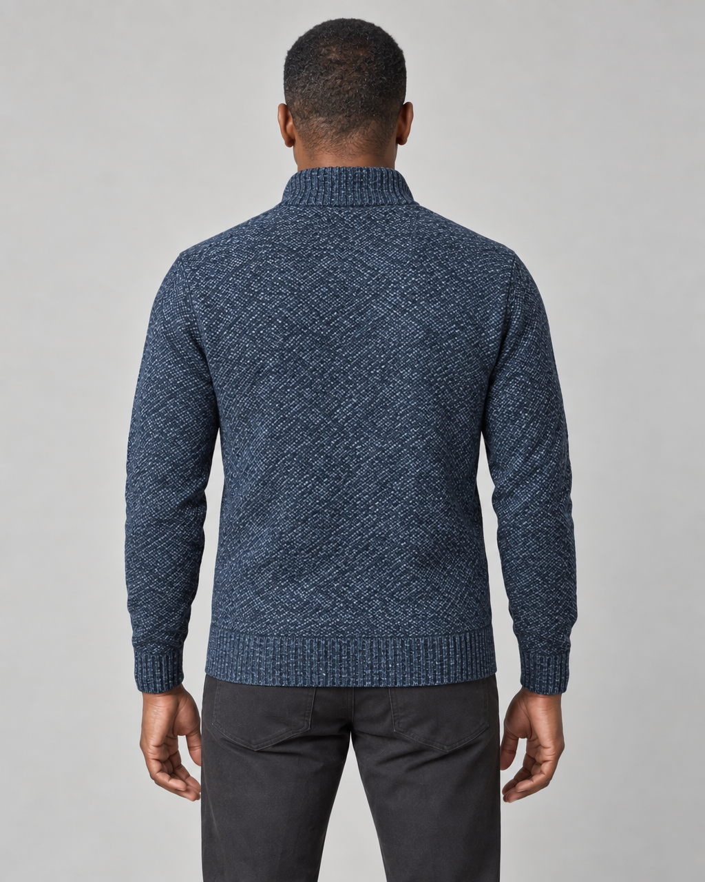Back view of a man wearing a blue textured knit jumper with a ribbed high neck, cuffs and hem