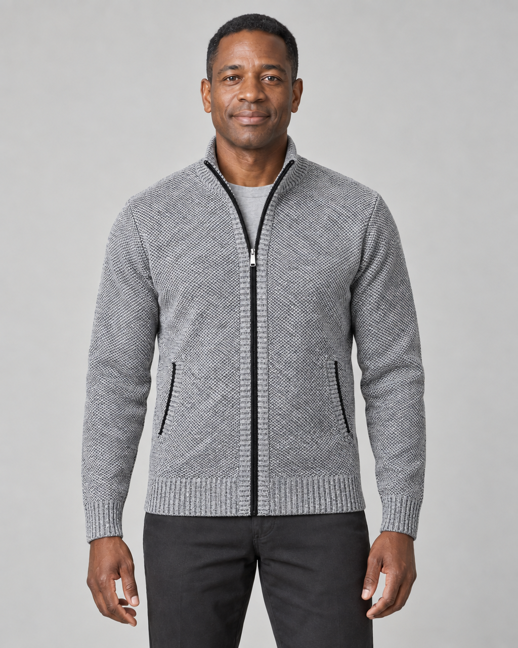 Front view of a light grey zip-up sweater with a stand collar, ribbed trims and black-edged front pockets.