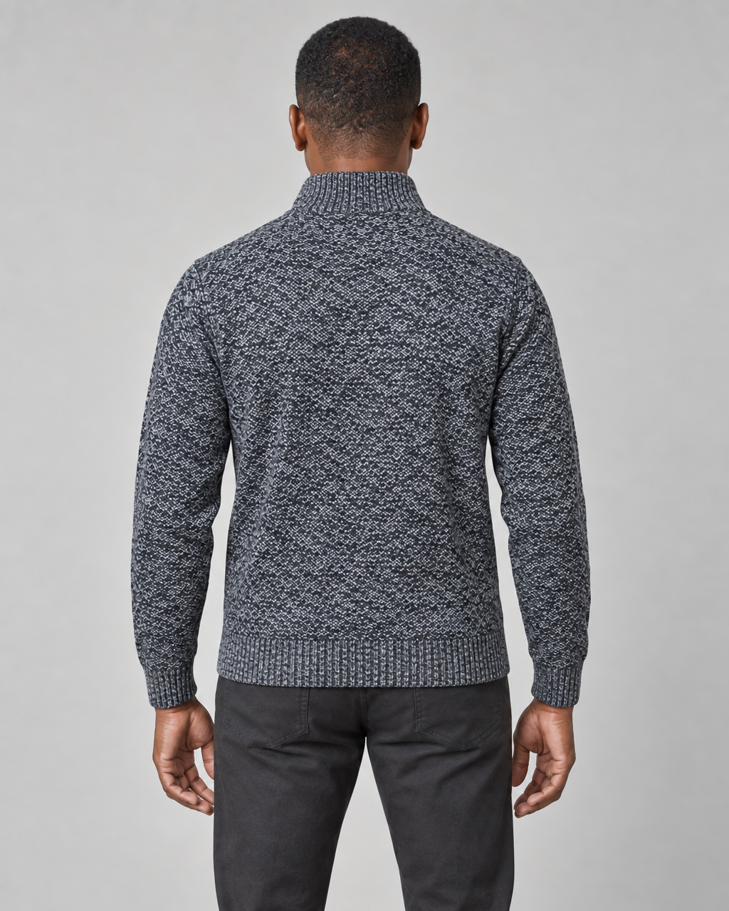 Rear view of a dark grey speckled jumper with a high ribbed neck, hem and cuffs.