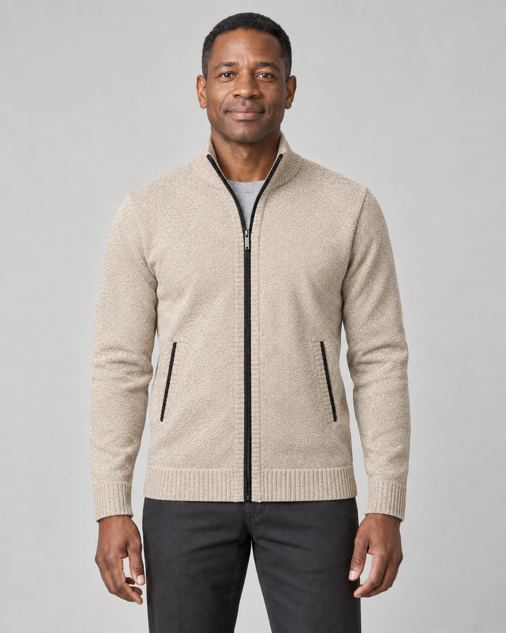 Front cropped view of a men's light khaki zip-up sweater with a stand collar and black zip and pocket trims.