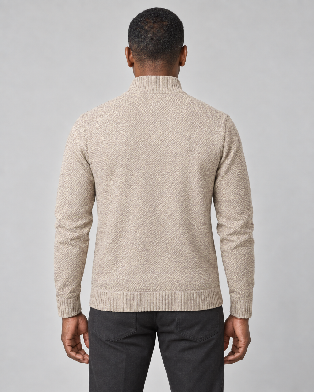 Back view of a man wearing a light beige textured jumper with a ribbed high neck, cuffs and hem