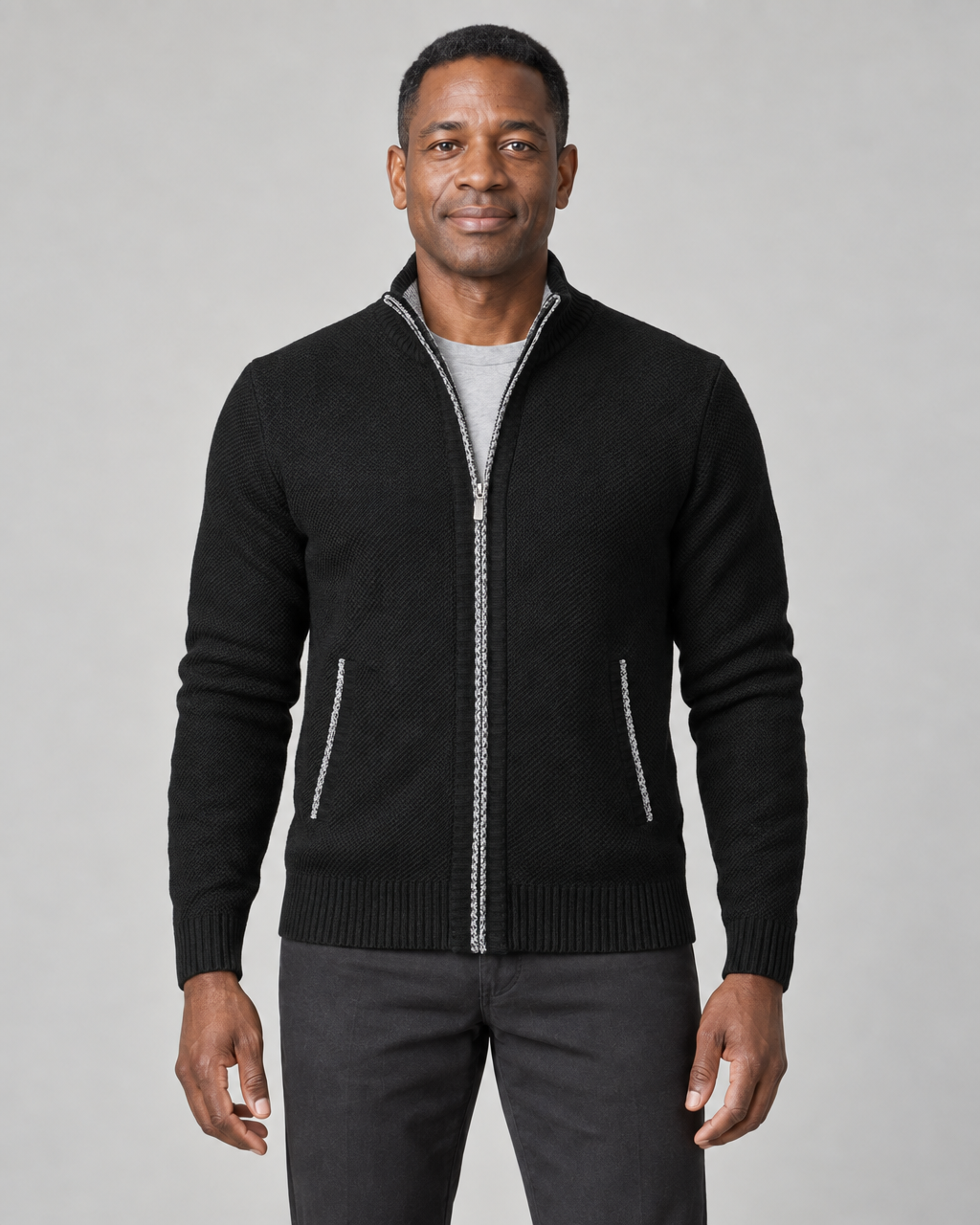 Front view of a black zip-up sweater with a ribbed stand collar, hem and cuffs, plus white trim at the zip and pockets.