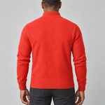 Rear view of a man wearing a bright orange knitted roll-neck jumper, cropped from head to thighs