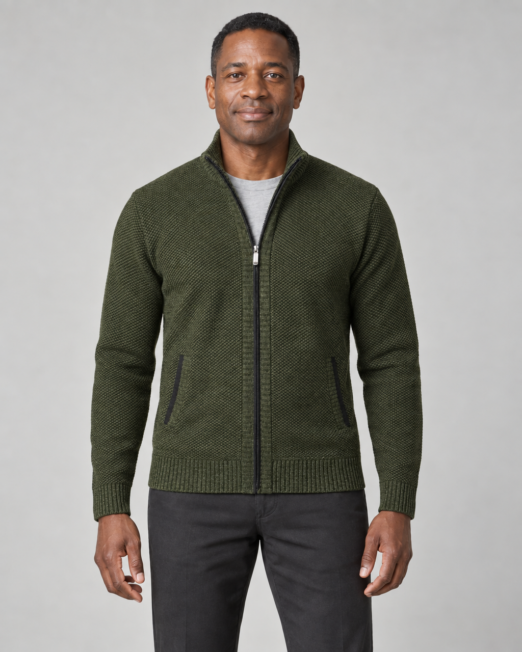Front cropped view of a man wearing a green textured zip-up sweater with a stand collar and two front pockets