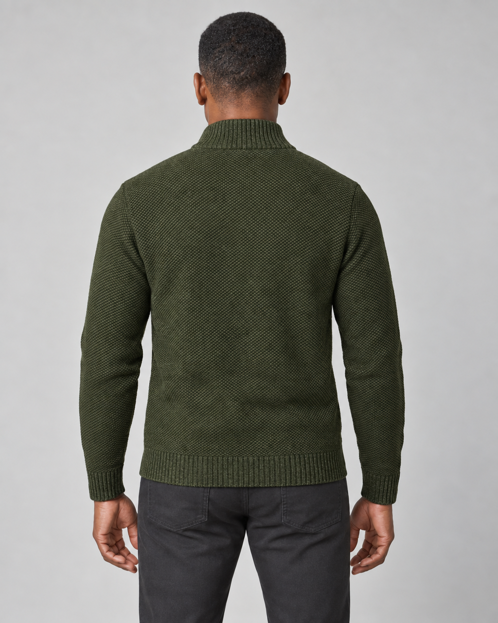 Back view of a man wearing an olive green textured sweater with a ribbed high collar, cuffs and hem.