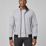 Front cropped view of a man wearing an open grey jacket with black trim and zipped side pockets.