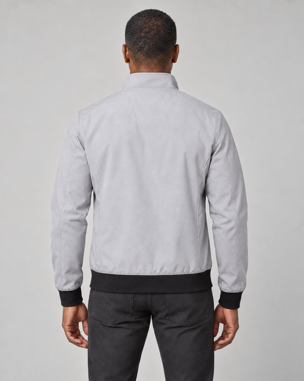 Back view of a light grey men's jacket with a raised collar and contrasting black cuffs and hem
