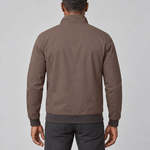 Back view of a model wearing a brown jacket with a raised collar and dark ribbed cuffs and hem.