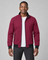 Front cropped view of a man wearing an open dark red jacket with black collar, cuffs, hem and zipped side pockets.