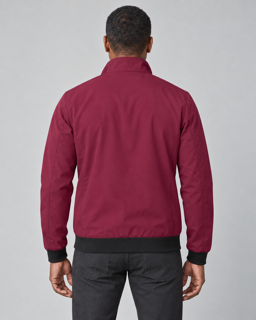 Back-view concept of a man wearing a burgundy jacket with a raised collar and black cuffs and hem.