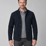 Front cropped view of a man wearing an open navy blazer with four buttons and two patch pockets.