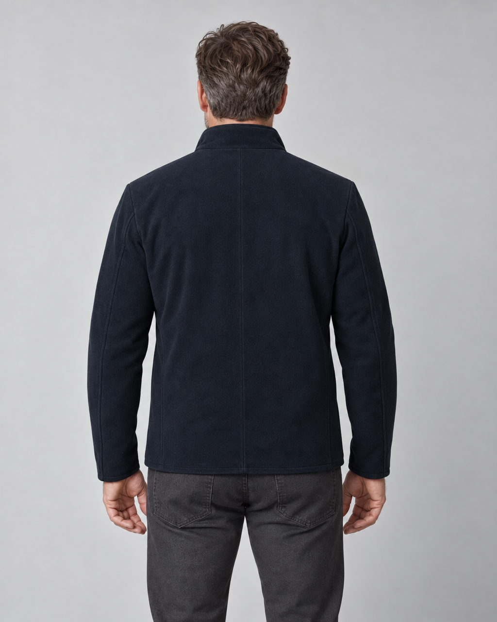 Conceptual back view of a man wearing a navy blue jacket with a stand collar.