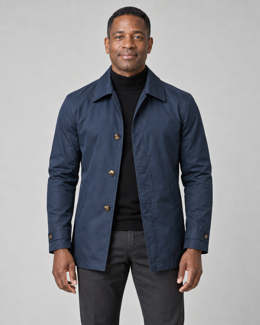 Front cropped view of a man wearing a navy collared coat with buttons and two side pockets
