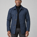 Front cropped view of a man wearing a navy collared coat with buttons and two side pockets