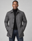 Front cropped view of a man wearing a grey button-front coat with a pointed collar and side pockets