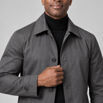 Close-up front view of a man wearing a grey coat with a pointed collar, dark buttons and buttoned cuff tabs