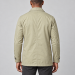 Rear cropped view of a man wearing a light khaki short coat with a pointed collar and buttoned cuff tabs.