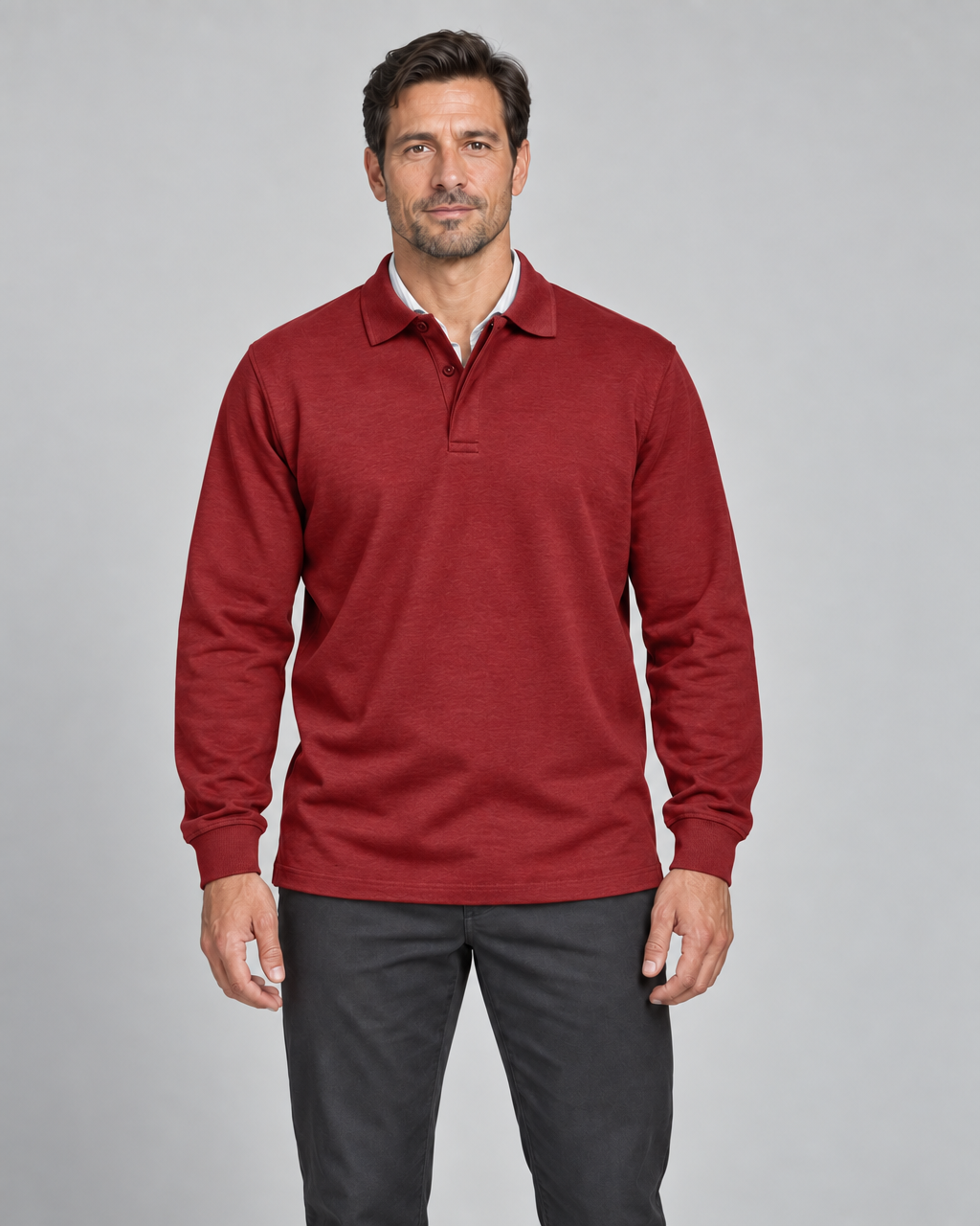 Front cropped view of a model wearing a red long-sleeved polo shirt with a two-button collar.